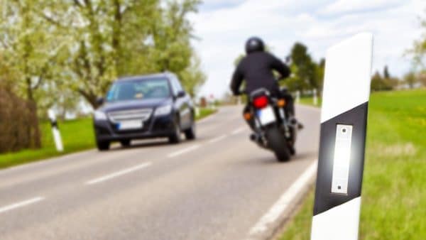 Motorcyclist Passing A Car On A Rural Road Stock Photo