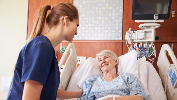 Female Nurse Consoling Elderly Female Patient Stock Photo